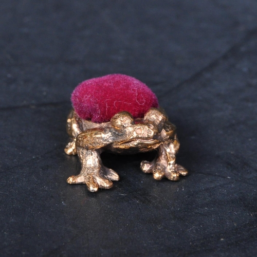 322 - A 20th century Victorian style brass cased frog pincushion. It measures approx. 2cm long.