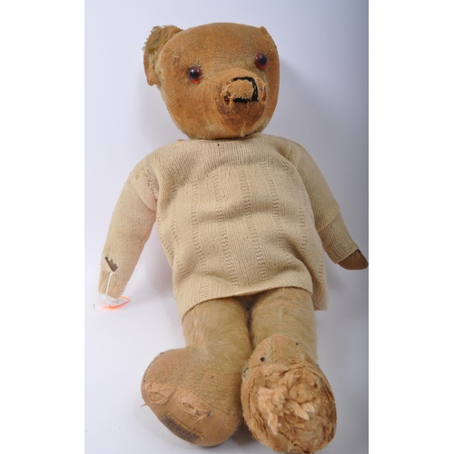 344 - A vintage mid 20th Century Merrythought teddy bear soft toy. Of typical form with wear commensurate ... 