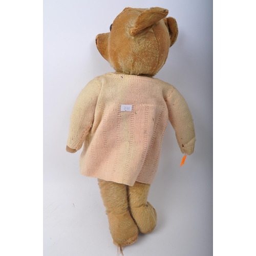 344 - A vintage mid 20th Century Merrythought teddy bear soft toy. Of typical form with wear commensurate ... 