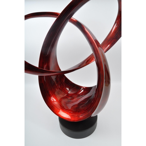 370 - A large contemporary resin free form sculpture. Having an abstract form with red and black striped c... 