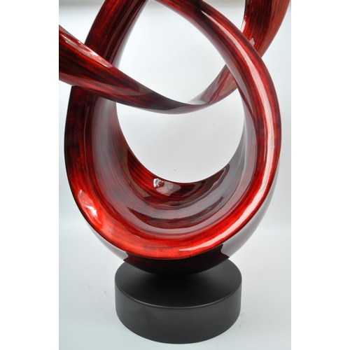 370 - A large contemporary resin free form sculpture. Having an abstract form with red and black striped c... 