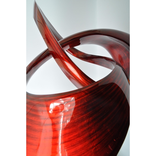 370 - A large contemporary resin free form sculpture. Having an abstract form with red and black striped c... 