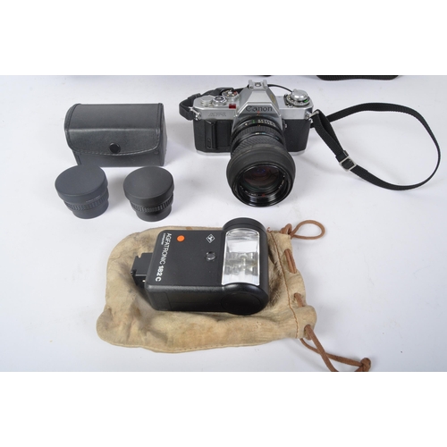 391 - A vintage 20th century Canon AV-1 film camera with Tokina lens. Accompanied by carry cases, manual, ... 