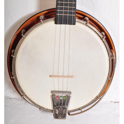 423 - A Banjolele of unknown make with nylon strings, faux  mother of pearl fret inlays, ebonised neck. Ho... 