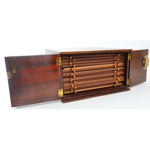 491 - A 20th century mahogany coin collectors display box. The box having twin doors opening to reveal dra... 