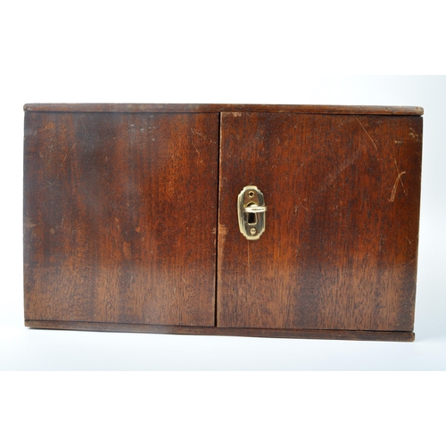 491 - A 20th century mahogany coin collectors display box. The box having twin doors opening to reveal dra... 