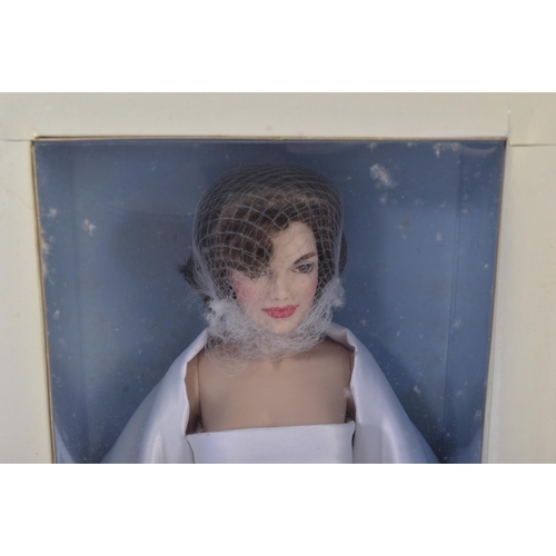 152 - An original Franklin Mint made Jackie Onassis doll. The porcelain doll with white satin dress, hand ... 