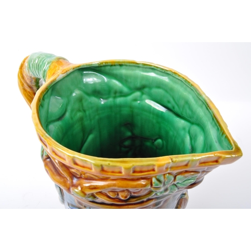 48 - A contemporary majolica style ceramic pottery jug in bright green, blue & yellow colourways depictin... 