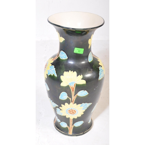 83 - A vintage 20th Century ceramic pottery vase. Having a green ground with foliate and floral painted d... 