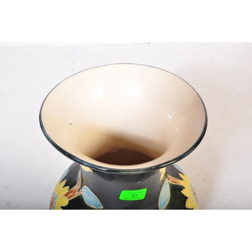 83 - A vintage 20th Century ceramic pottery vase. Having a green ground with foliate and floral painted d... 