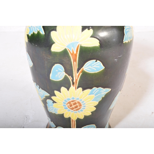 83 - A vintage 20th Century ceramic pottery vase. Having a green ground with foliate and floral painted d... 