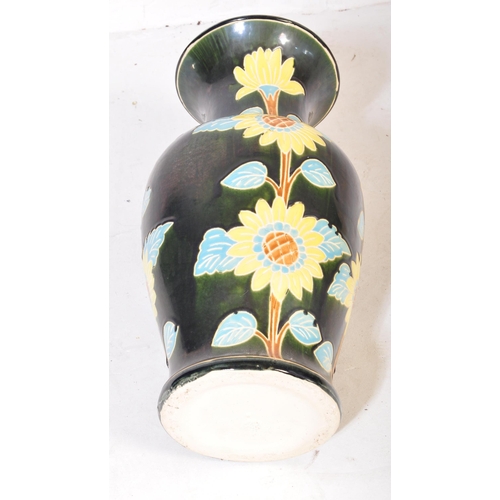 83 - A vintage 20th Century ceramic pottery vase. Having a green ground with foliate and floral painted d... 