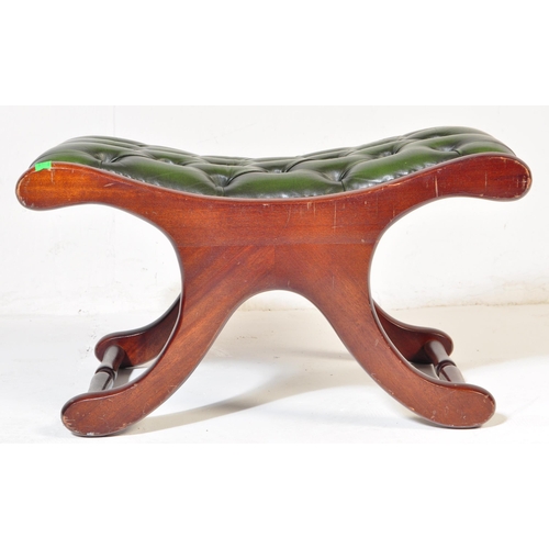 1008 - A 20th century leather button back Chesterfield sofa footstool ottoman having green button back leat... 