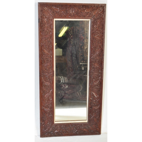 1012 - Early 20th century carved hardwood Asiatic wall mirror. Of rectangular form having carved relief wor... 