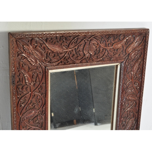 1012 - Early 20th century carved hardwood Asiatic wall mirror. Of rectangular form having carved relief wor... 