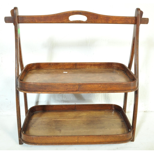 1045 - A 19th Century mahogany wood two tier butlers tray. Having a bar lifting support to top, with curved... 