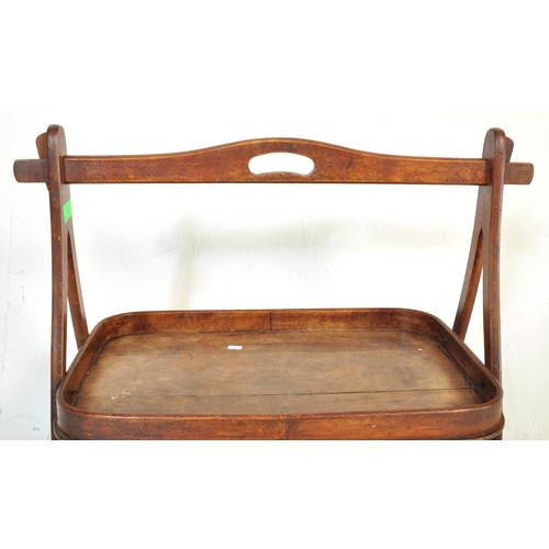 1045 - A 19th Century mahogany wood two tier butlers tray. Having a bar lifting support to top, with curved... 