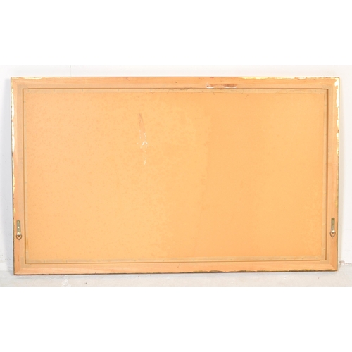 1048 - A large early 20th Century gilt over mantel mirror. Of rectangular form with gilt wood with bevelled... 