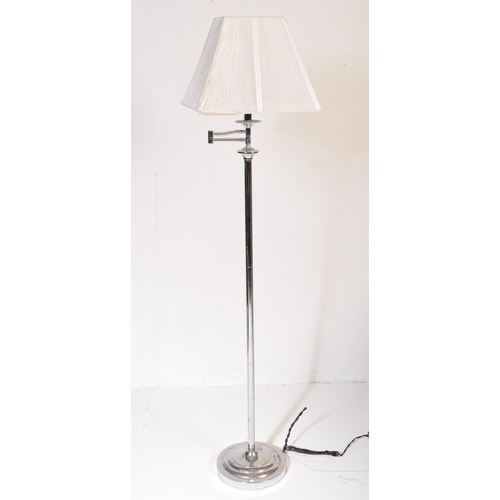 591 - A contemporary floor standing standard lamp light. Having a white netted shade, with a chrome tubula... 