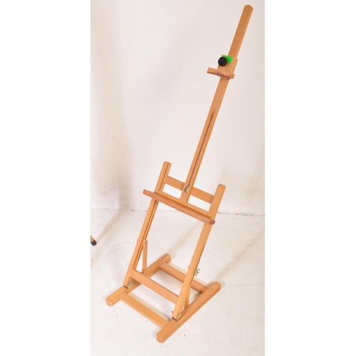 598 - A contemporary modern artists beech wood adjustable easel stand raised on tripod supports. Together ... 