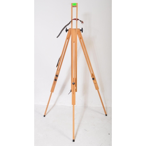 598 - A contemporary modern artists beech wood adjustable easel stand raised on tripod supports. Together ... 