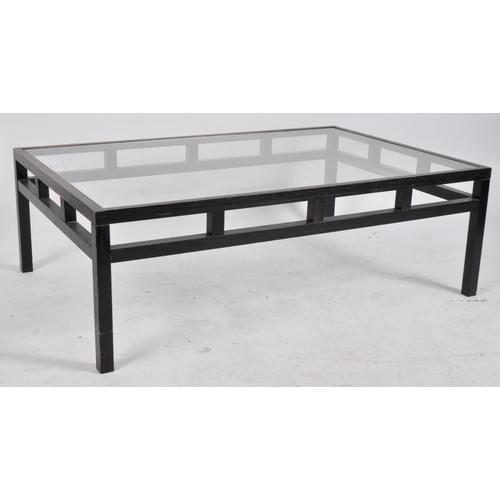 612 - A large late 20th Century dark veneered coffee table / low table having an inset clear glass top wit... 