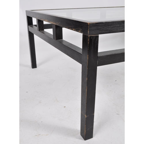 612 - A large late 20th Century dark veneered coffee table / low table having an inset clear glass top wit... 