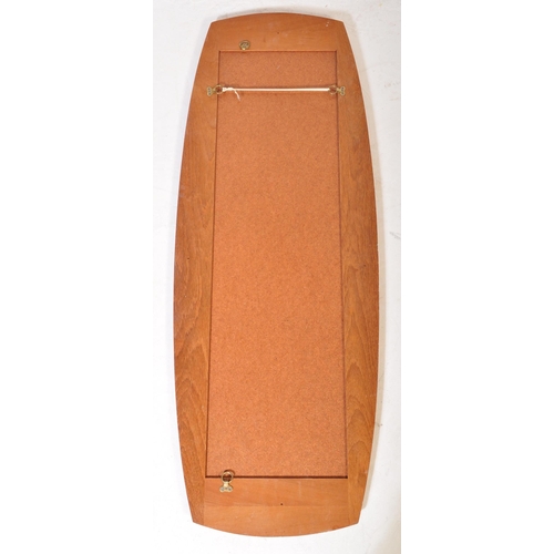637 - A retro vintage mid 20th Century teak framed wall hanging mirror of curved rectangular form. It meas... 