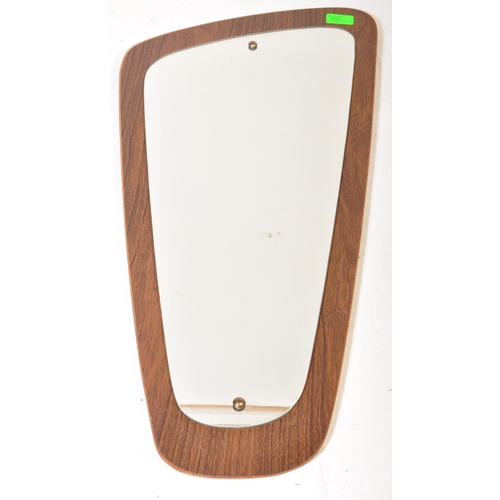 650 - A retro vintage mid 20th Century teak framed asymmetric mirror of tapering form. It measures approx.... 