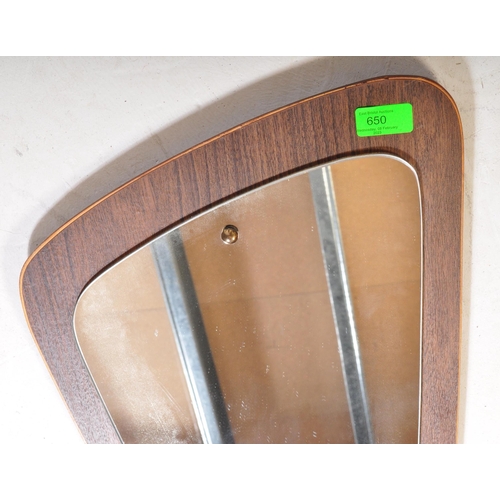 650 - A retro vintage mid 20th Century teak framed asymmetric mirror of tapering form. It measures approx.... 