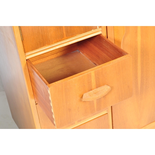 657 - A retro mid 20th Century walnut veneer childrens wardrobe / chest tallboy having a fall length wardr... 