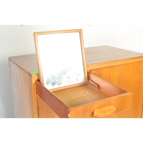 657 - A retro mid 20th Century walnut veneer childrens wardrobe / chest tallboy having a fall length wardr... 