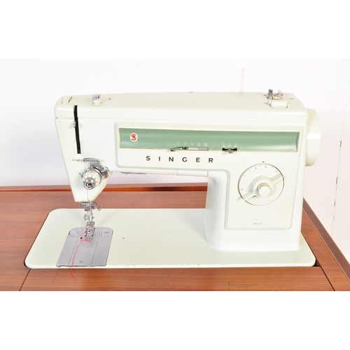 668 - A retro mid Century circa 1970s teak wood sewing table cabinet / desk combination having fold out ac... 