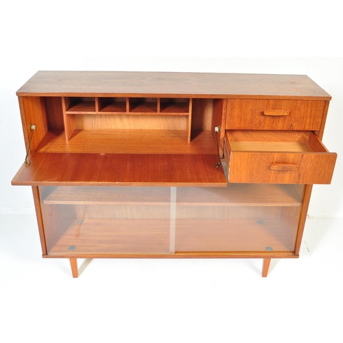 700 - Avalon - Mid 20th Century teak wall unit cabinet. Rectangular form with pull down door to left with ... 