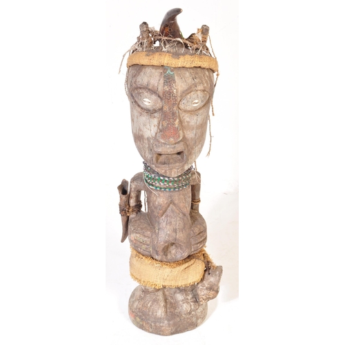 707 - A large 20th Century tribal African figure with horn set to head with inset shells to eyes. Glass be... 