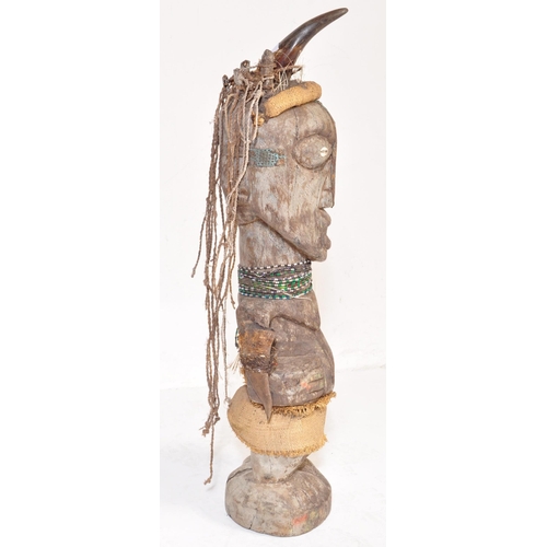 707 - A large 20th Century tribal African figure with horn set to head with inset shells to eyes. Glass be... 