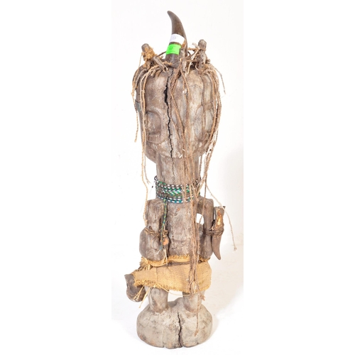 707 - A large 20th Century tribal African figure with horn set to head with inset shells to eyes. Glass be... 