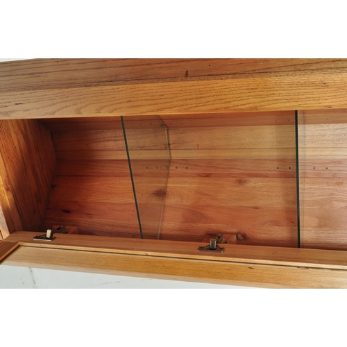 727 - A Contemporary solid oak corner cabinet in the manner of Oak Furniture Land having a glazed cabinet ... 