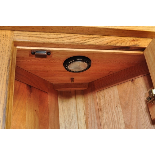 727 - A Contemporary solid oak corner cabinet in the manner of Oak Furniture Land having a glazed cabinet ... 