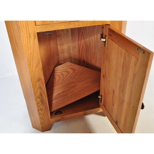 727 - A Contemporary solid oak corner cabinet in the manner of Oak Furniture Land having a glazed cabinet ... 