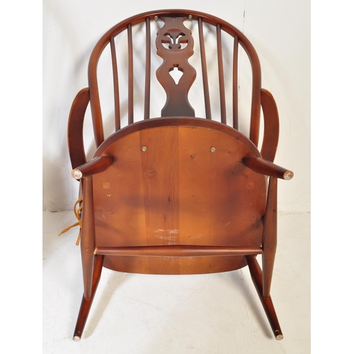 744 - A pair of retro vintage mid 20th Century beech & elm fleur de lis low arm chairs. Both having round ... 