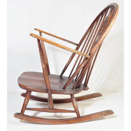 750 - A retro vintage mid 20th Century dark beech and elm rocking chair. With rounded spindle wheelback wi... 