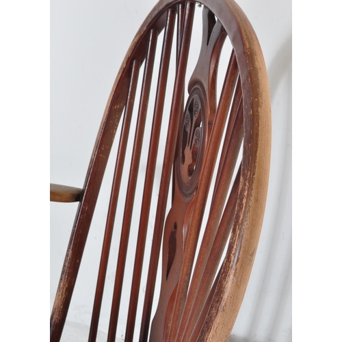 750 - A retro vintage mid 20th Century dark beech and elm rocking chair. With rounded spindle wheelback wi... 