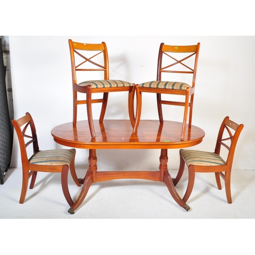 802 - A vintage 20th Century yew wood dining table with chairs. The table of oval form with veneer top ree... 