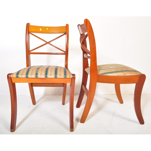 802 - A vintage 20th Century yew wood dining table with chairs. The table of oval form with veneer top ree... 