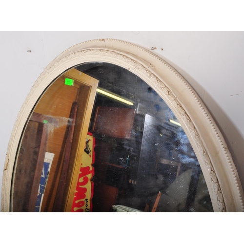 813 - A 19th Century Victorian over mantel wall mirror of oval form having a large glass mirror panel set ... 