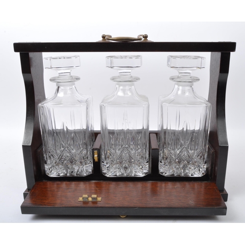 858 - A pair of early 20th century Decanter tantalus's. Each having cut glass decanters in mahogany brass ... 