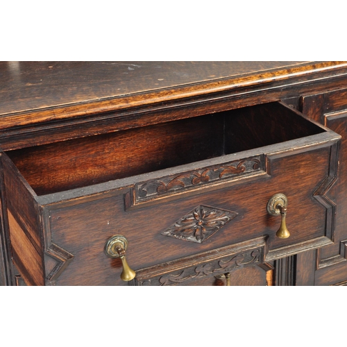 937 - An early 20th century Jacobean Revival oak sideboard. The credenza having a decorated gallery back o... 