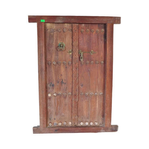 945 - An early 20th Century Indian hand carved solid teak wood door. Small form with two doors with carved... 