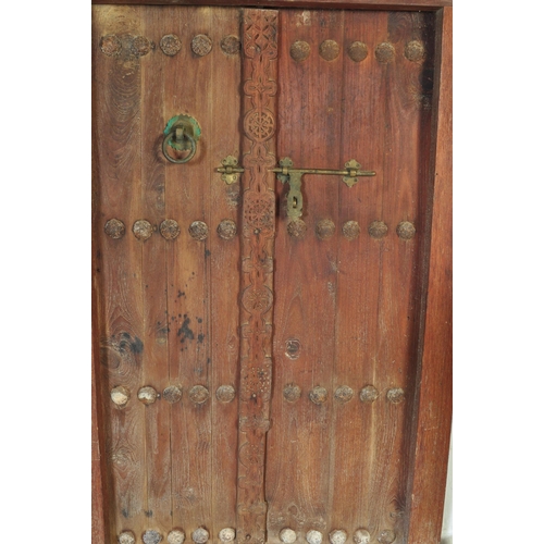 945 - An early 20th Century Indian hand carved solid teak wood door. Small form with two doors with carved... 